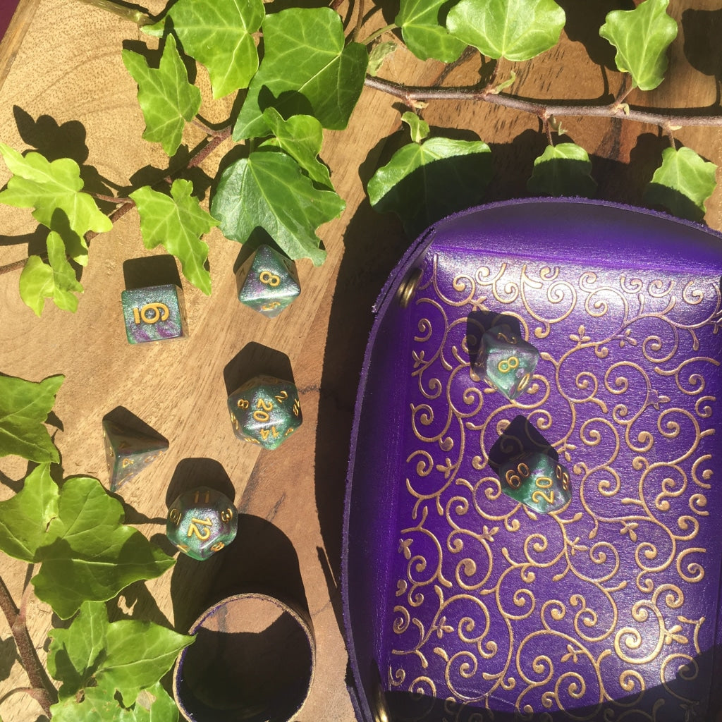 a purple vase sitting in front of a plant